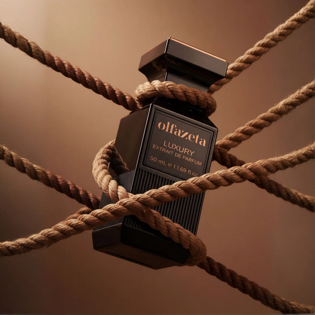 Czarny flakon Olfazeta by Chogan Luxury N°75 owinięty beżowymi sznurami na ciepłym brązowym tle