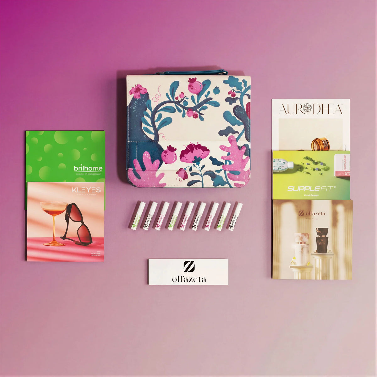 Monsterkit Olfazeta by Chogan: flesjes, etui met bloemenmotief en merkcatalogi op roze-mauve achtergrond