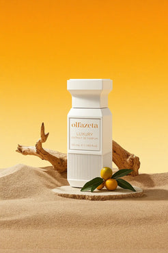 Witte flacon Olfazeta by Chogan Luxury N°112 op een stenen sokkel in het zand, kumquats en drijfhout